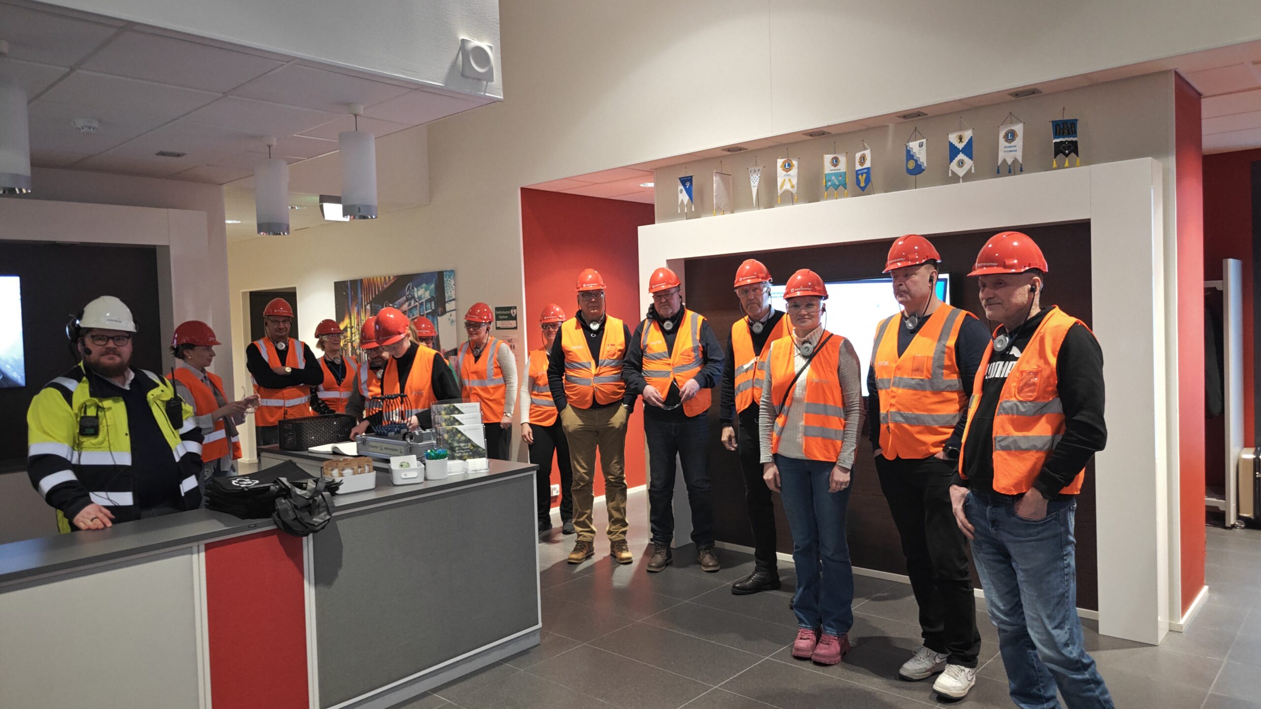 Ihmisjoukko eteistilassa turvavarusteet päällään