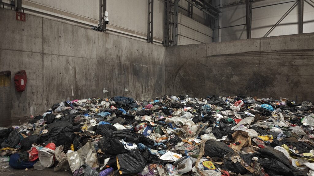 Jätteitä tunnistava kameralaitteisto asennettuna jätekasan viereen varastohallissa